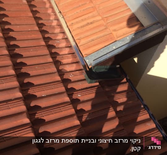 רעפים חומים על גג עם תעלת ניקוז מתכתית